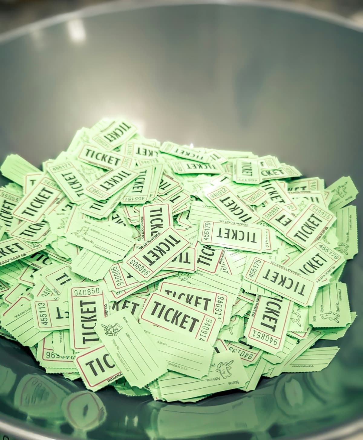 A bowl filled with green raffle tickets